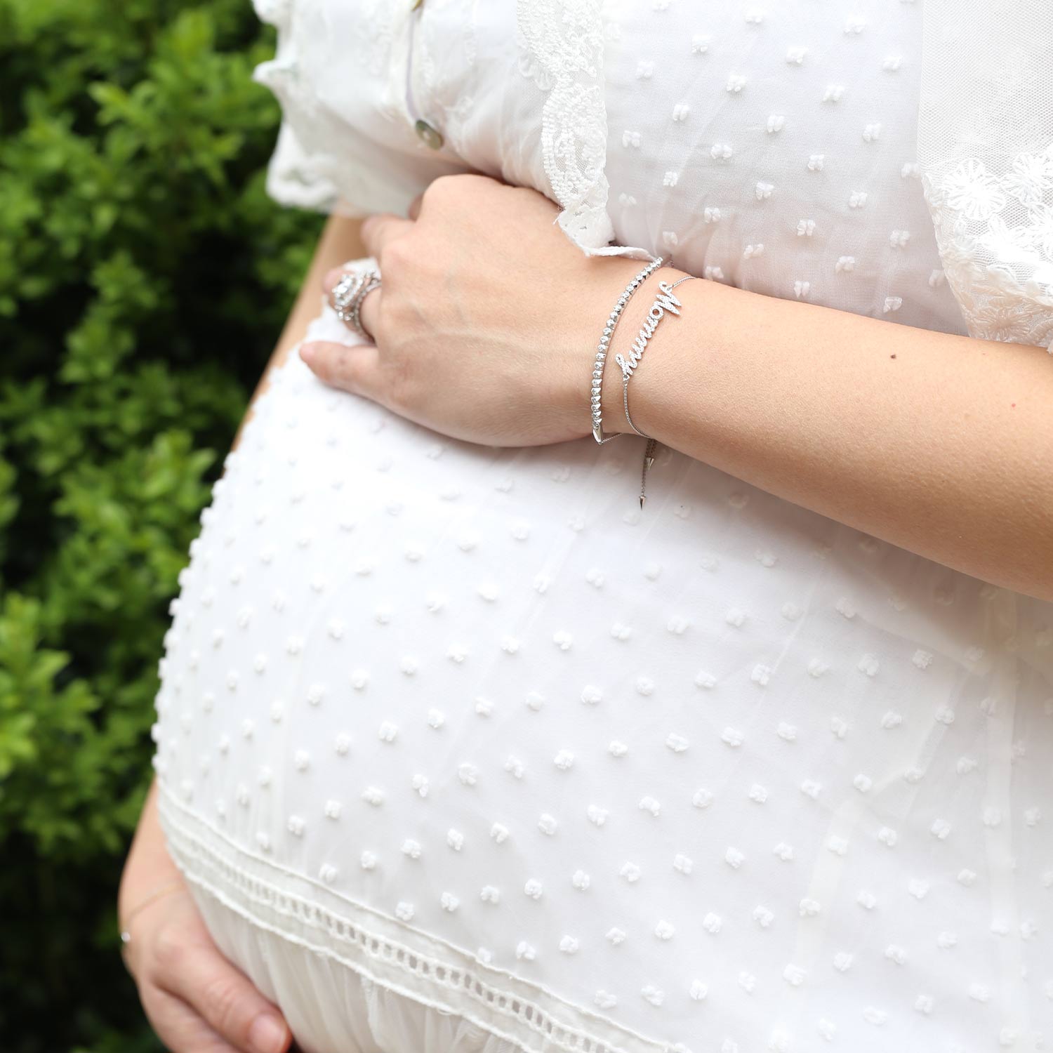 Pregnant woman with push present diamond jewelry featuring a Mommy bracelet