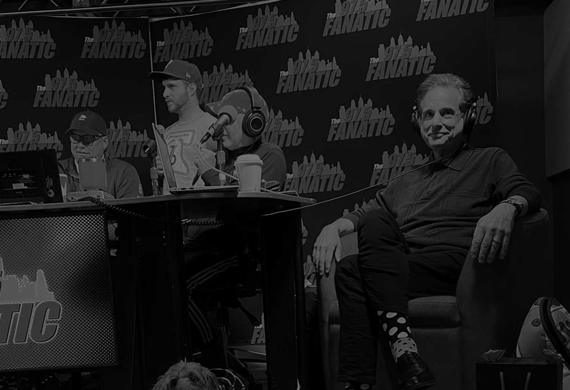 Steve sitting in a chair with headphones on next to the 97.5 fanatic crew