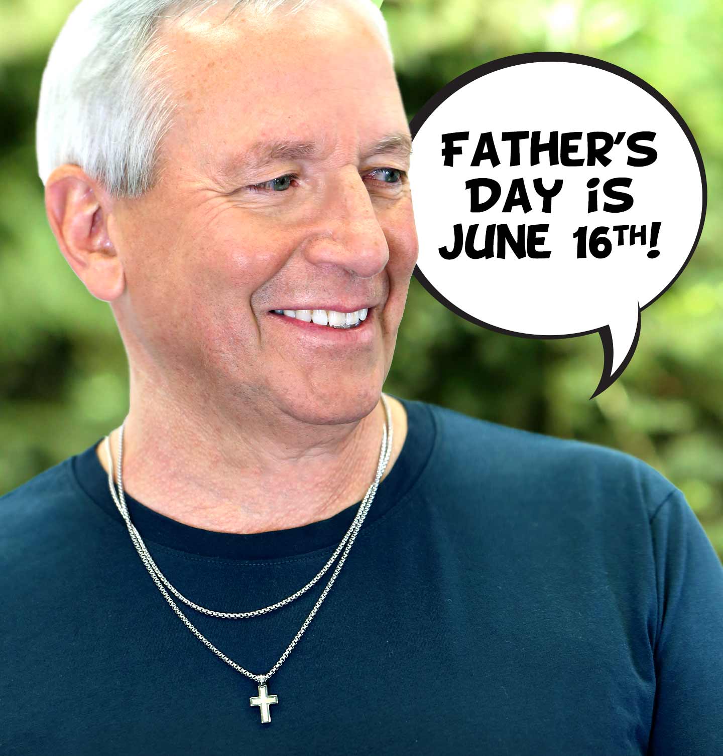 A smiling father wearing a cross and chain necklace.