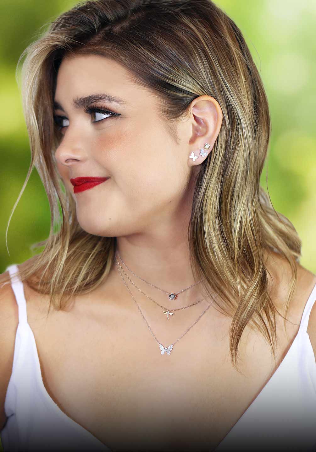A women with a red lip looking to the side modeling our Garden Diamond Jewelry Collection in layers.