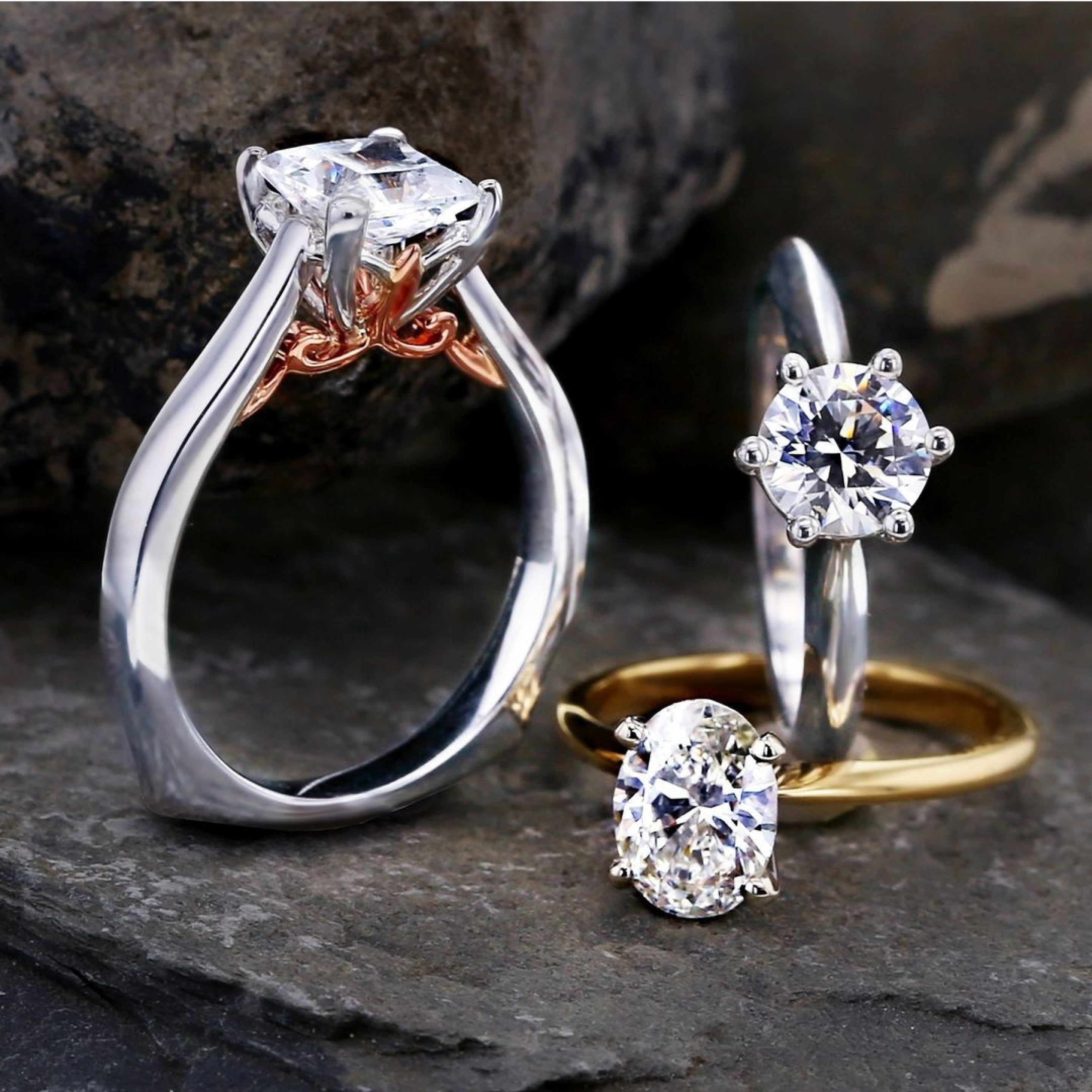 Three engagement rings with different shaped diamonds such as oval, round, and princess which is squared.