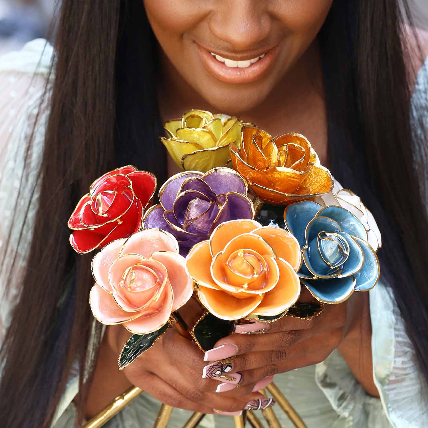 A woman holding a bouquet of our most famous gold dipped roses.