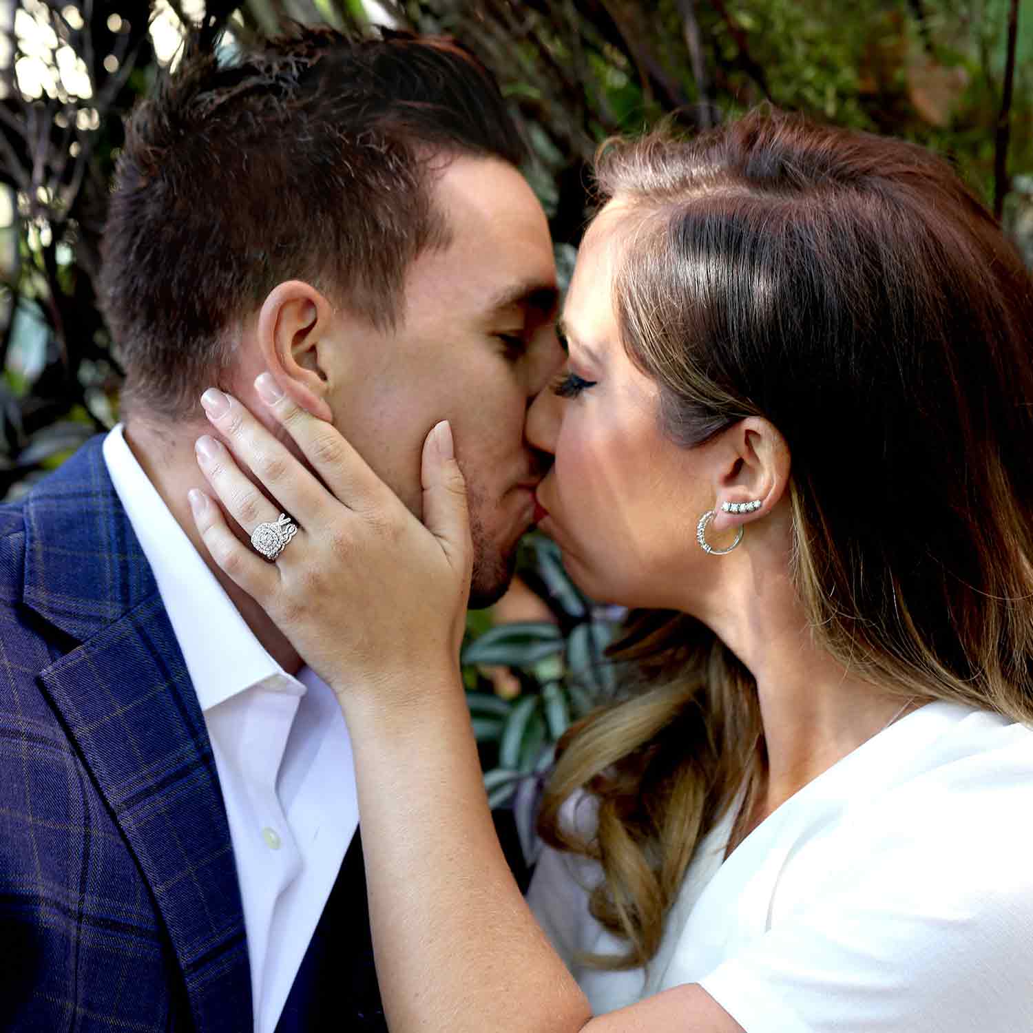 A man and woman kissing with the woman's hand on the mans face.