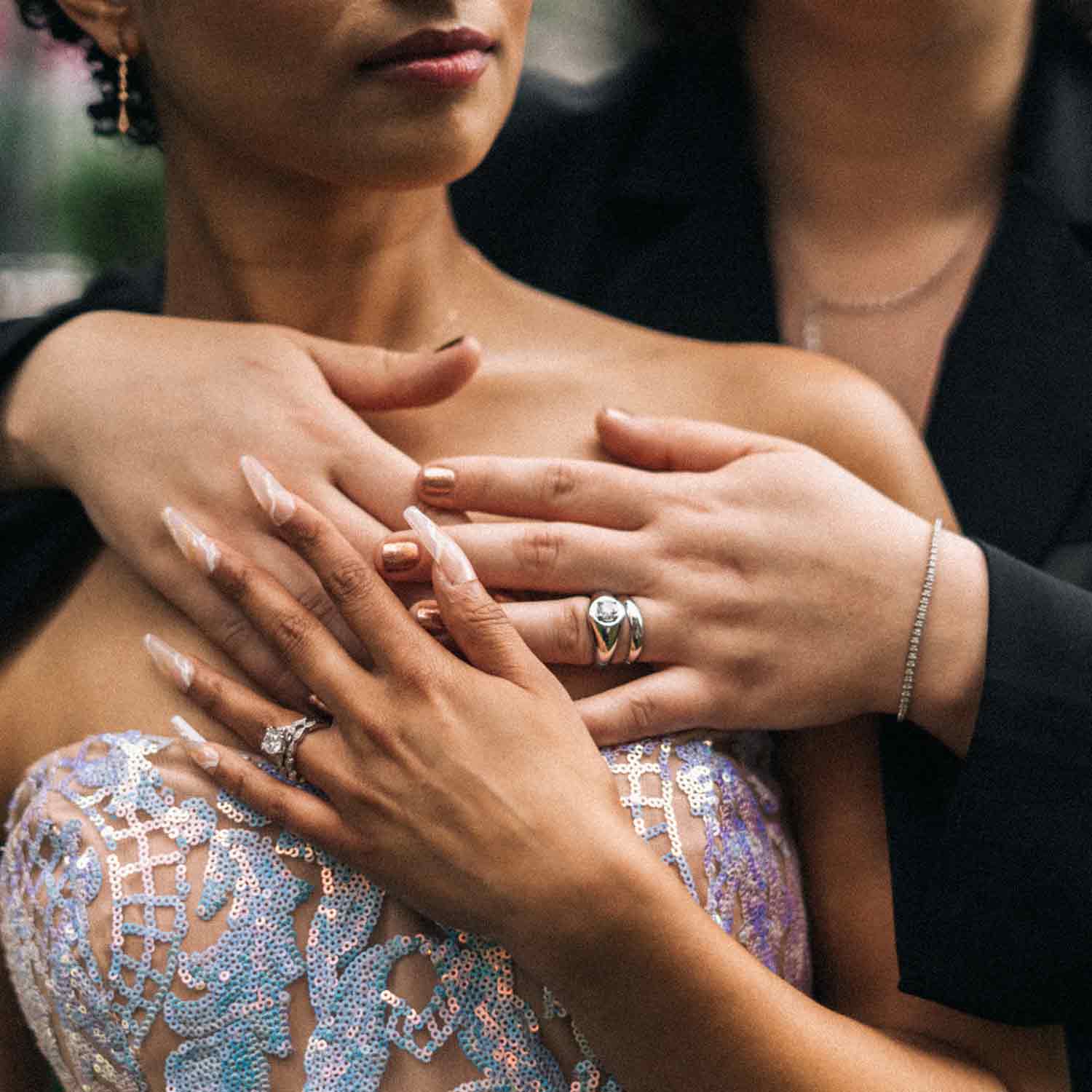 A woman being hugged from behind by another woman with their hands over each other's..