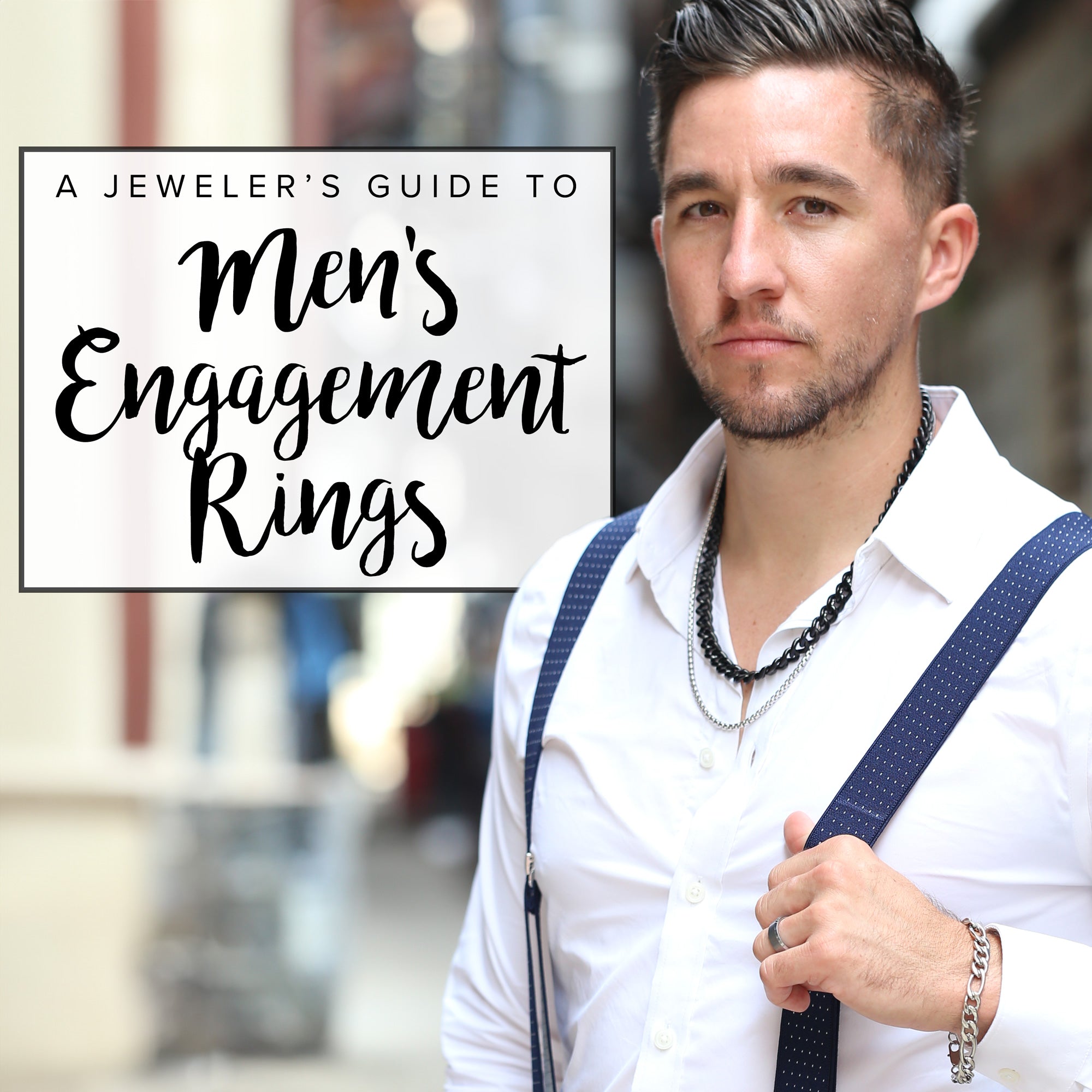 A man with a blue suit and crossed hands shows off two of our sharp men's engagement rings.