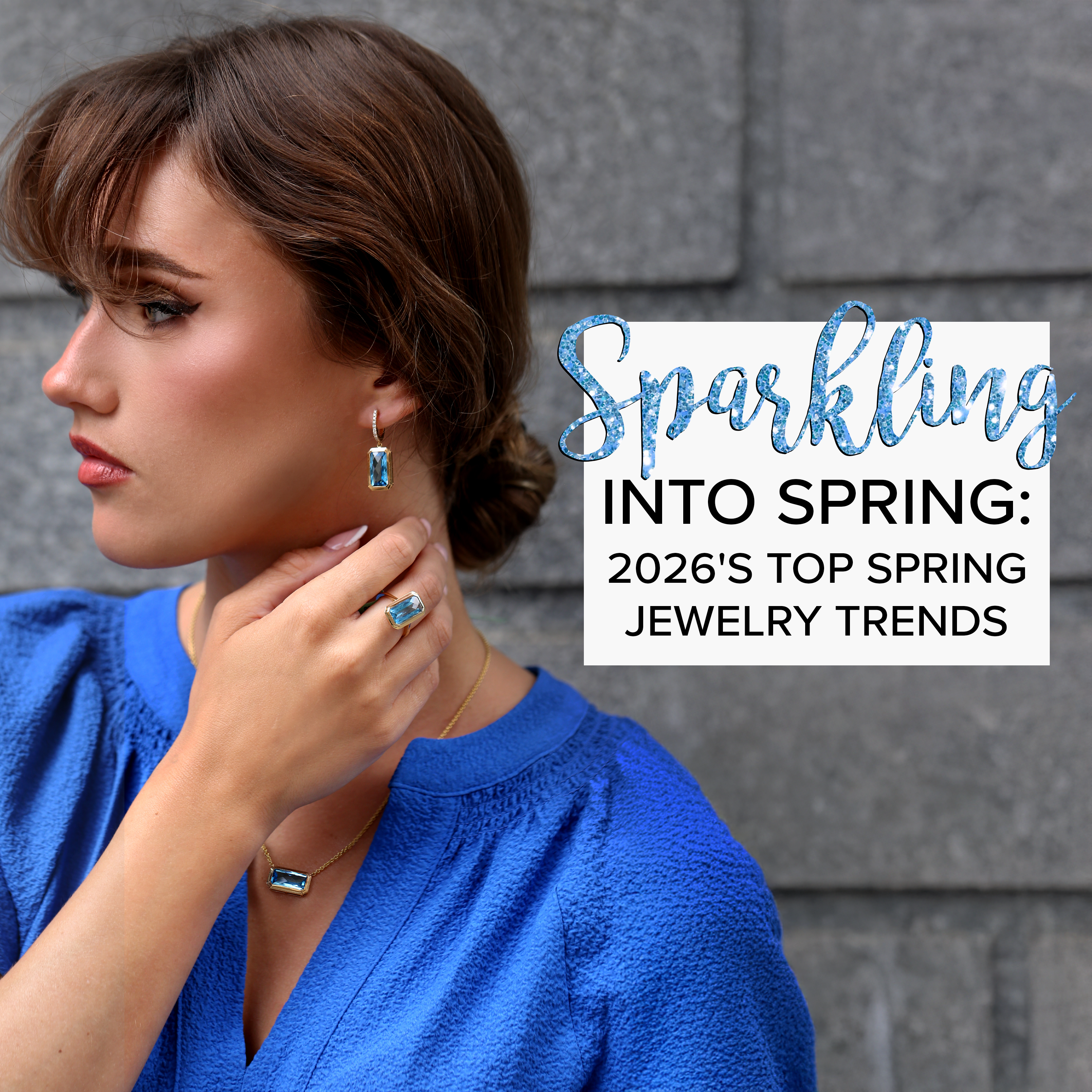 A woman wearing a blue shirt complimenting her Blue Topaz earrings, ring, and necklace set.