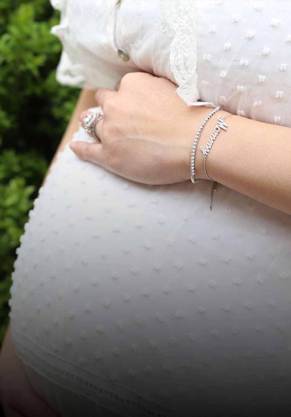 Picture of a baby bump featuring a mommy bracelet and tennis bracelet. Links to push presents