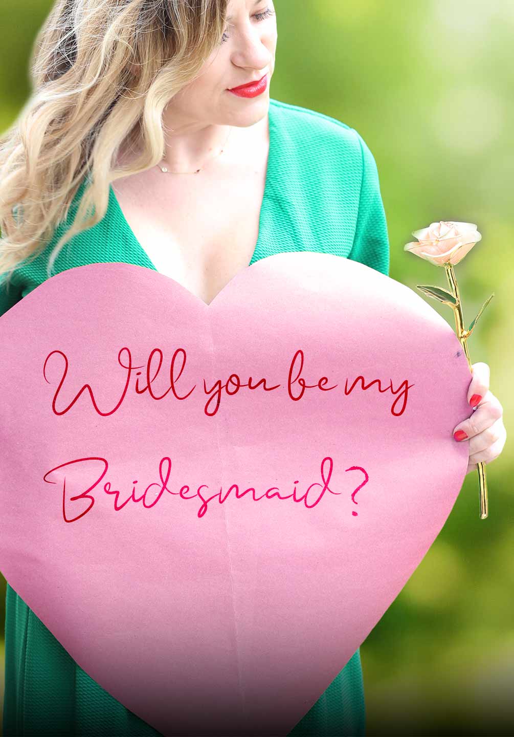 A women holding a 'will you be my bridesmaid' sign holding a Gold Dipped Rose and wearing a gold necklace.