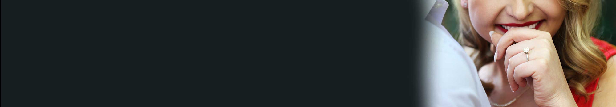 A girl smiling with a solitaire engagement ring on her ring finger.