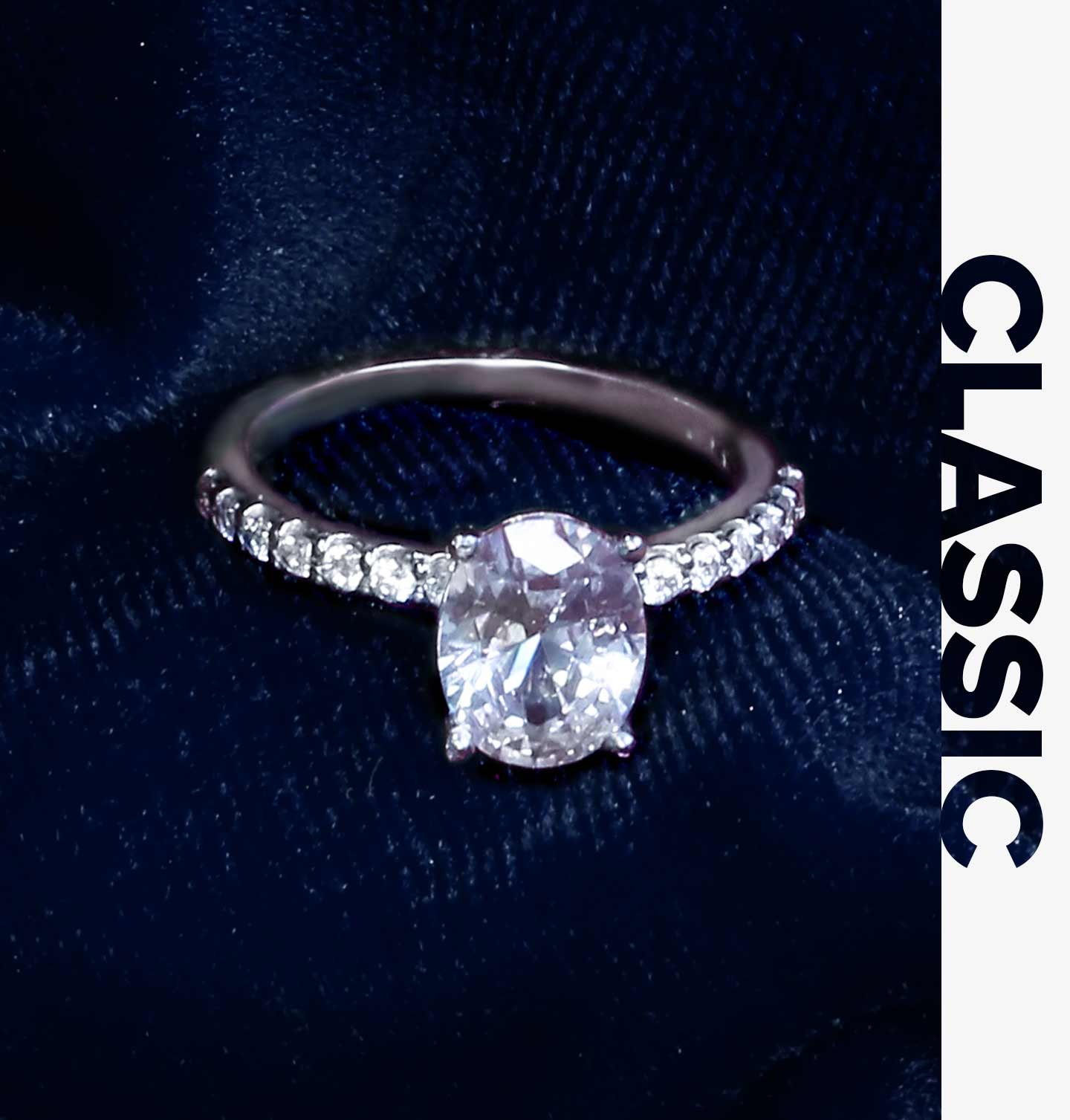 A classic diamond engagement ring with common prong set round brilliant diamonds set along the shank and an oval cut center diamond.
