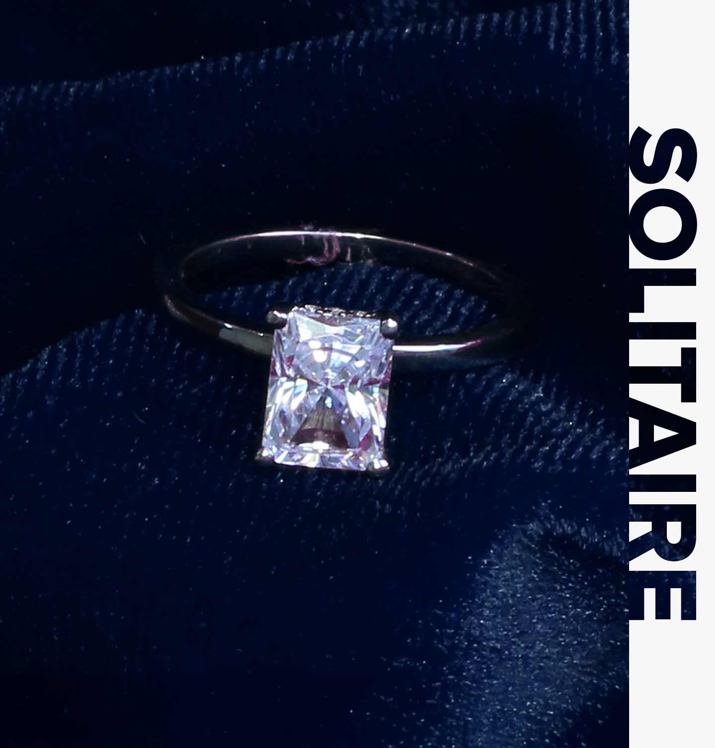 A 14 karat white gold solitaire style engagement ring with a radiant cut center diamond.