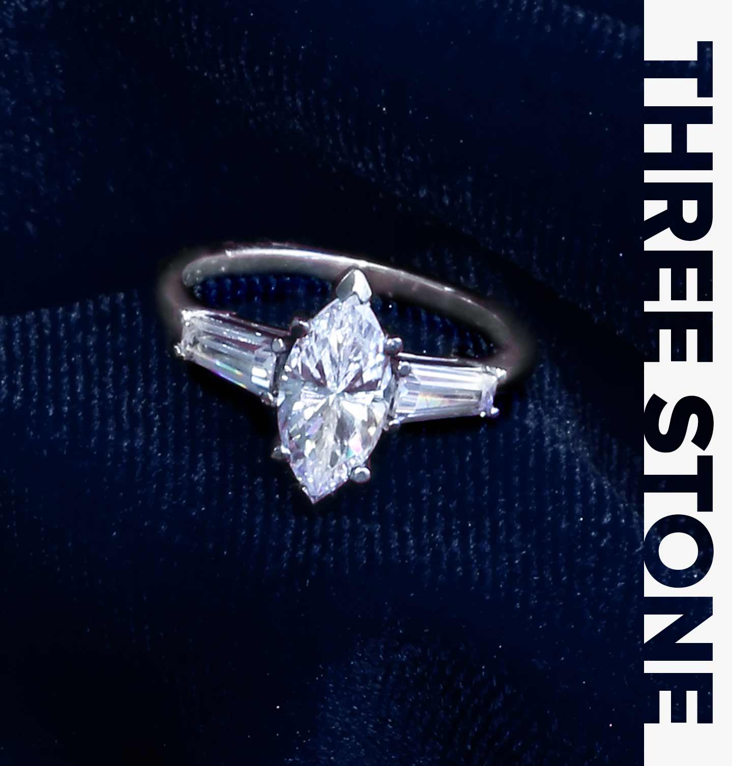 Three stone engagement ring with a marquise center diamond and baguette side diamonds.