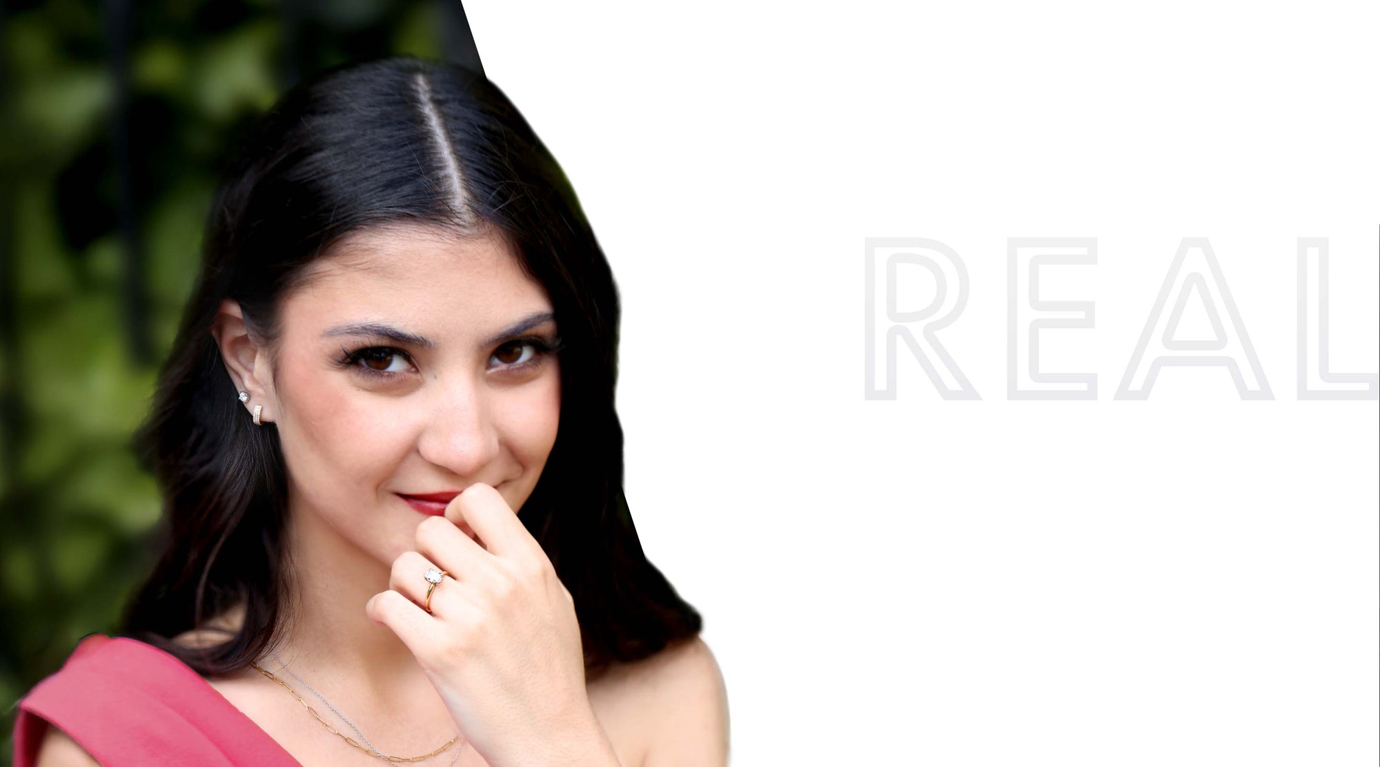 Woman with dark hair and a pink top, with 'REAL' text on a white background. Wearing one of our Classic Christa Diamond Engagement Rings.