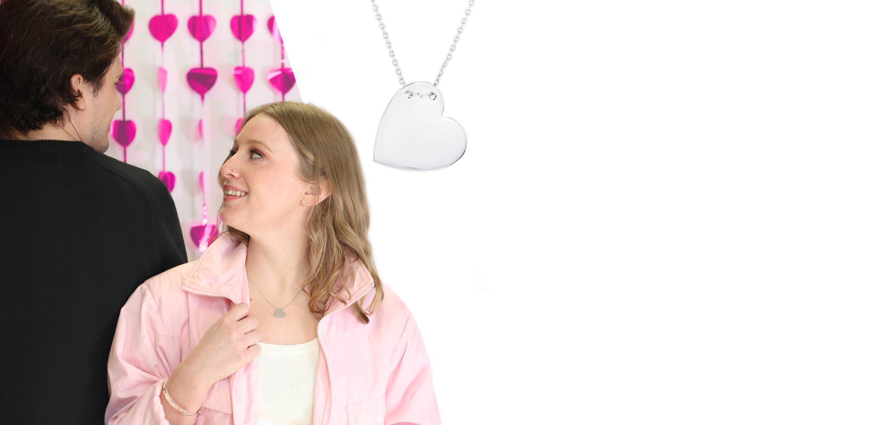 A couple looking in each others eyes and a silver heart necklace.