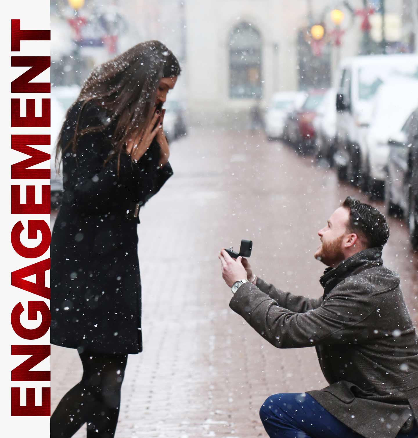 A man on his knee proposing in the snow with an engagement ring from Steven Singer Jewelers.