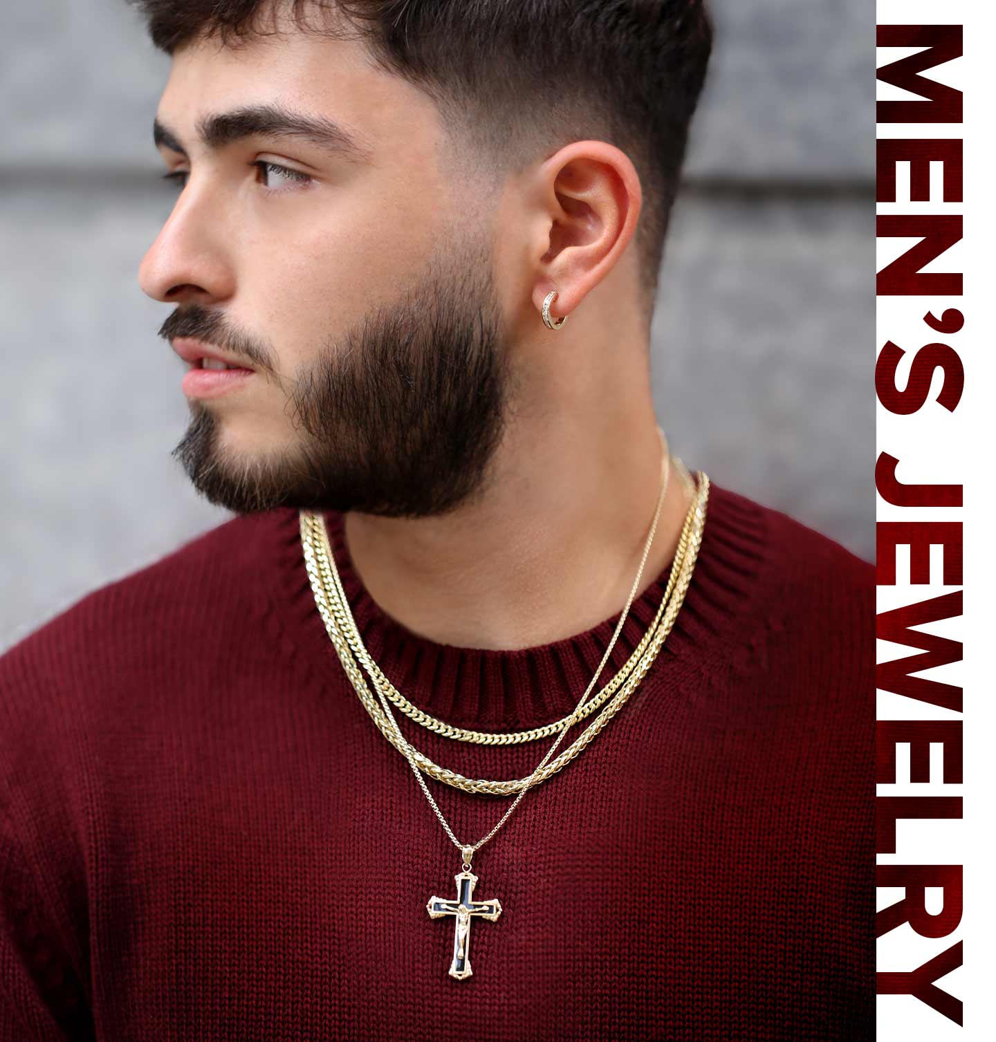 A man wearing layered gold chains, a cross, and hoops.