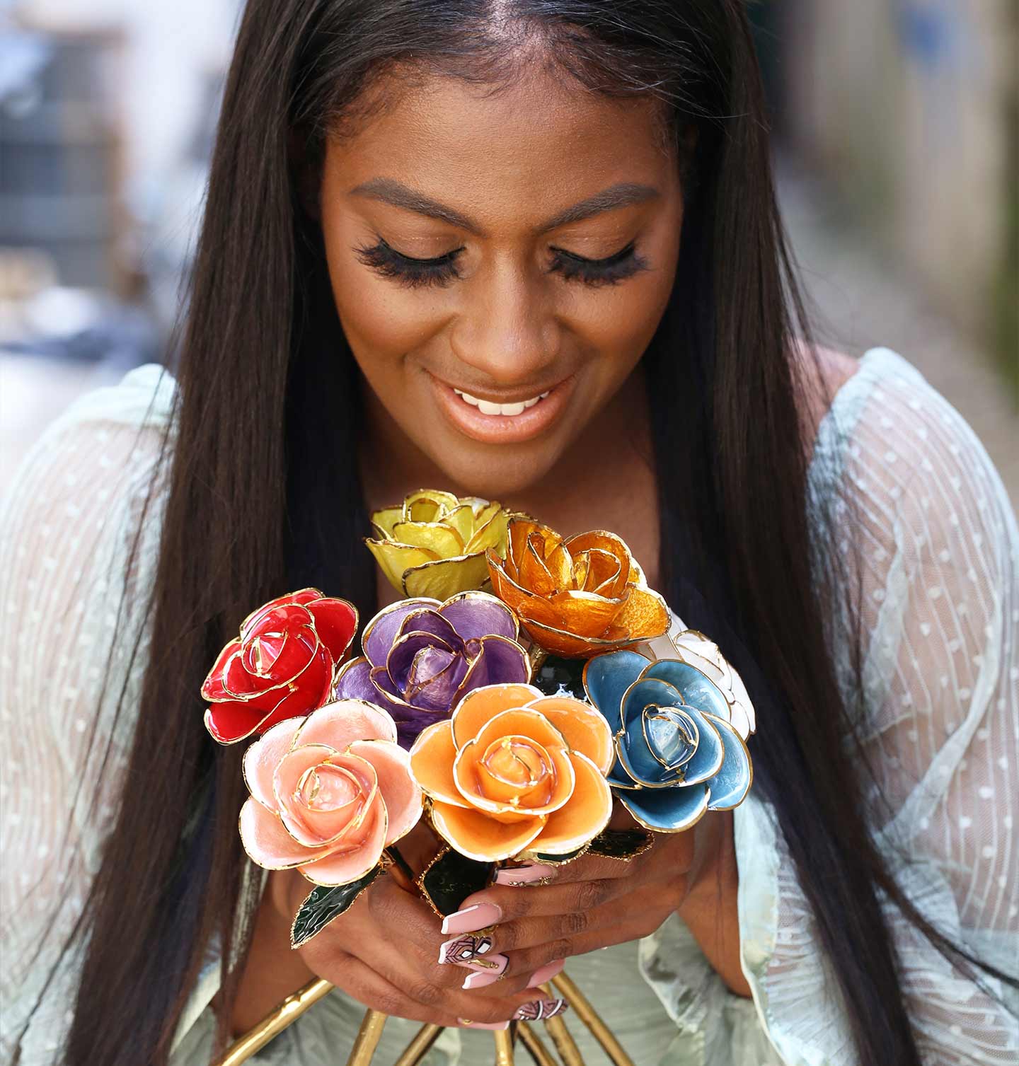 Woman holding a bouquet of colorful gold dipped roses from Steven Singer.