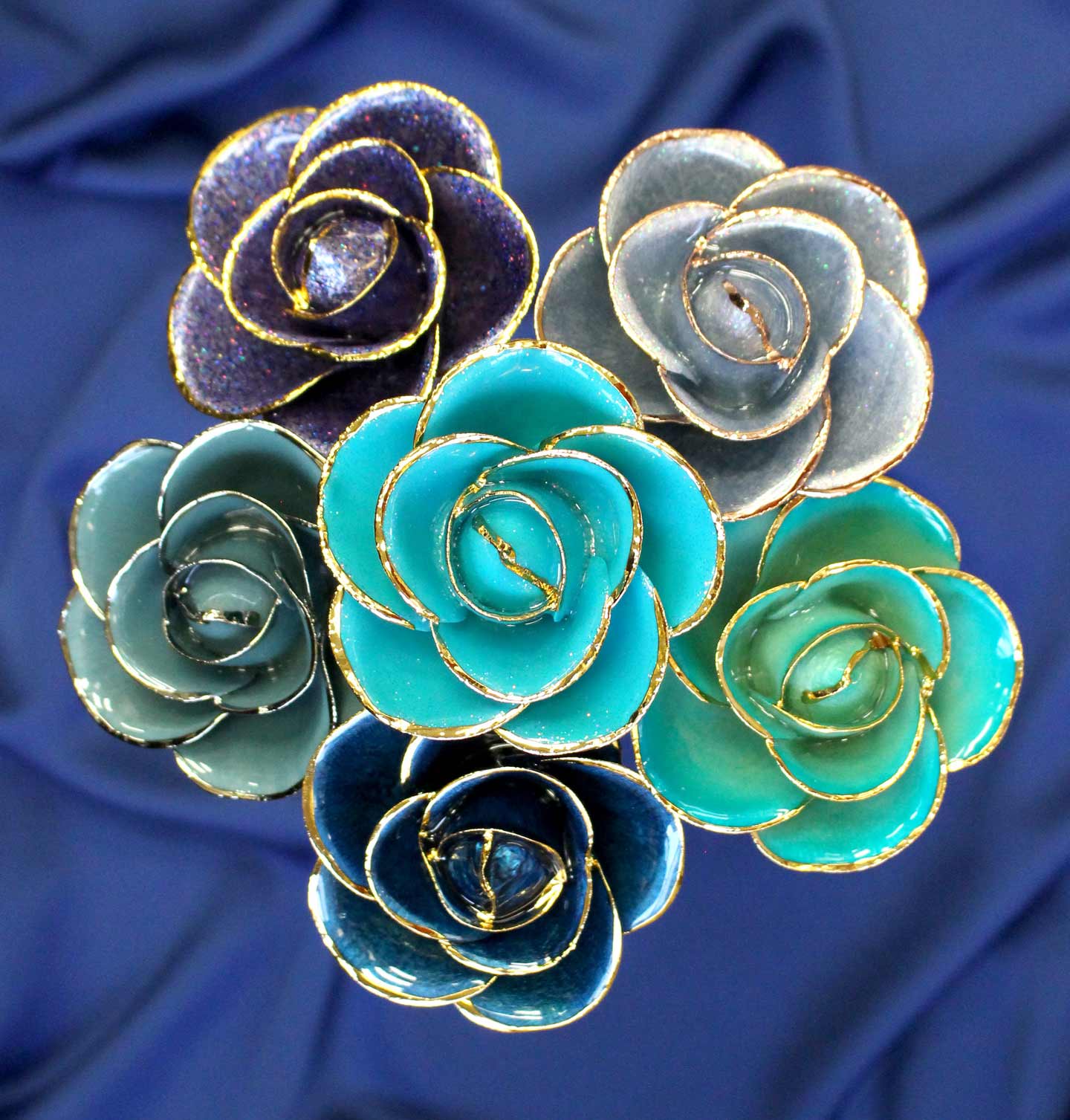 A bouquet of 24 Karat Gold Dipped Roses in blue, gray, and green hues.