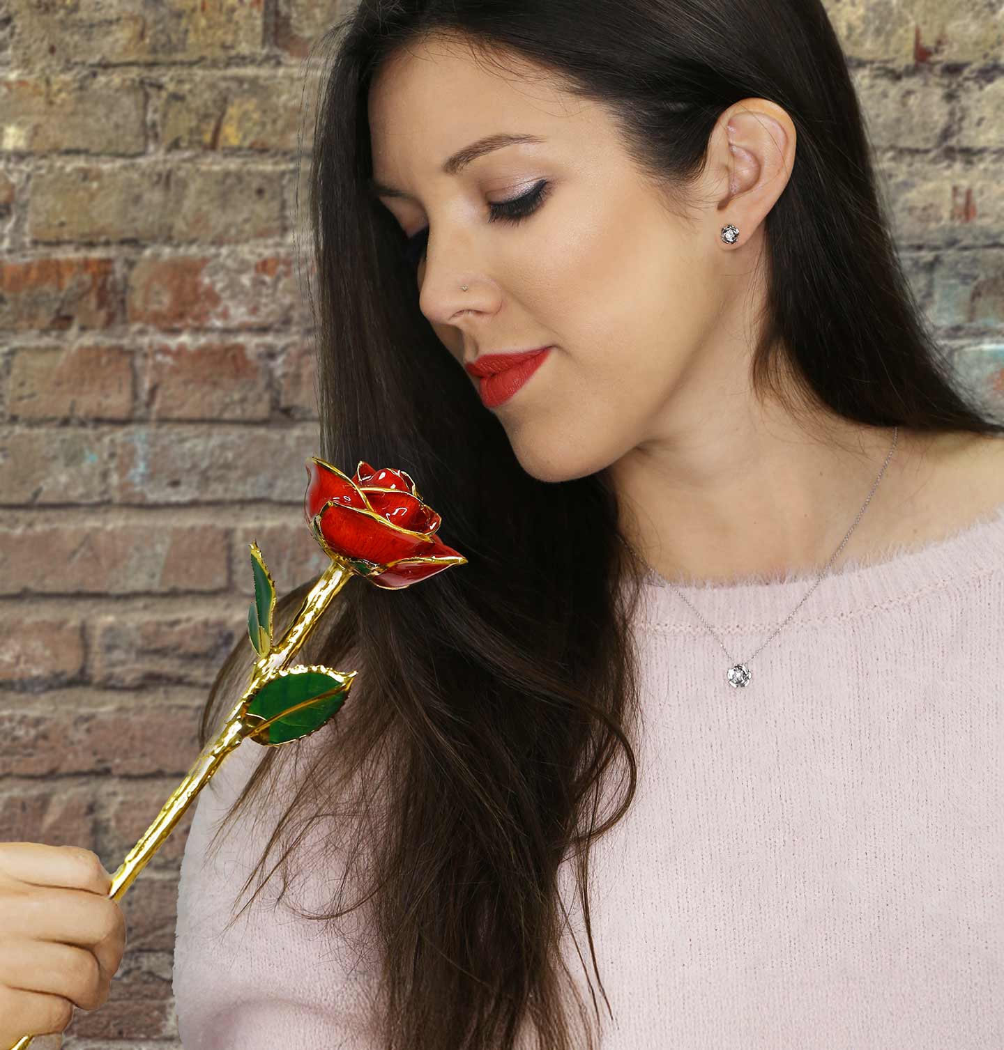 A woman looking down at our Classic Red 24 Karat Gold Dipped Rose.