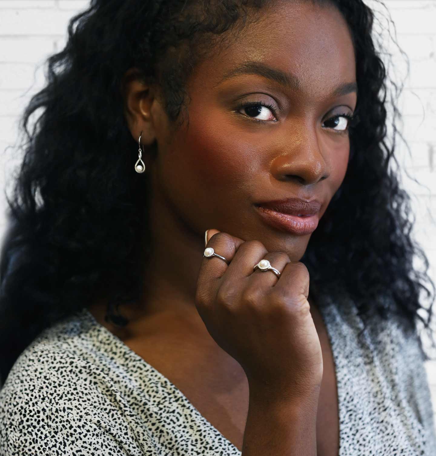 Woman with jewelry looking thoughtfully to the side wearing June Birthstone Jewelry.