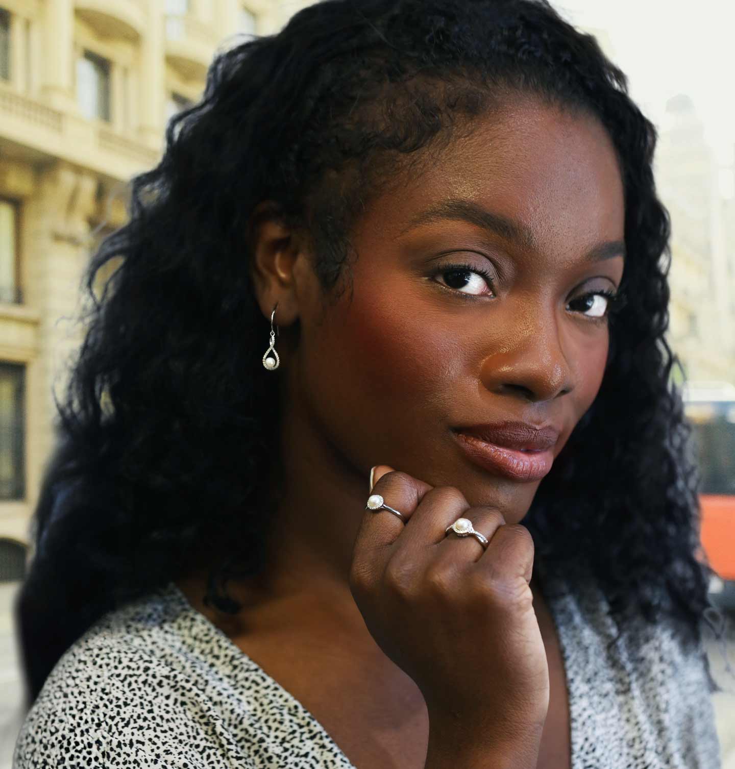Woman in an urban setting wearing jewelry from our June Birthday Collection.