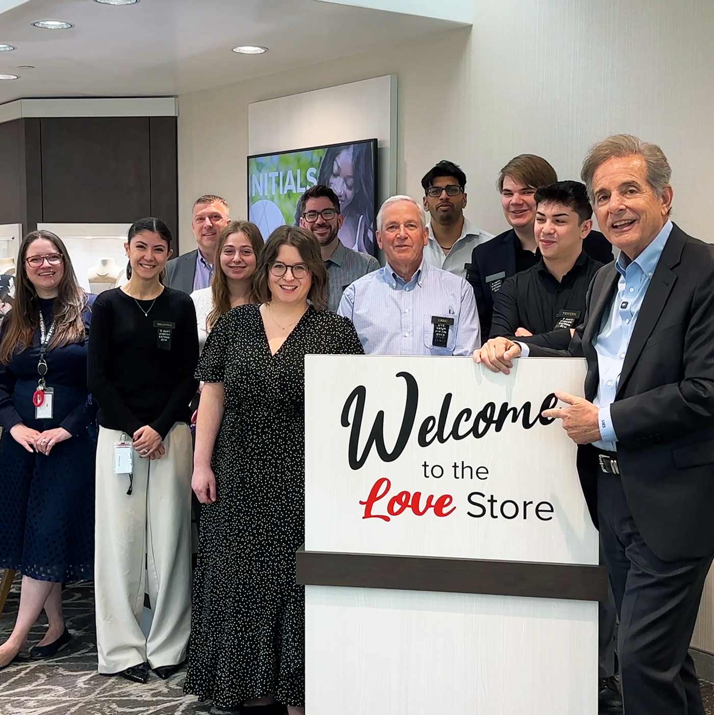 Steven Singer staff posing with a 'Welcome to the Love Store' sign in our new location in Newtown, Bucks County.