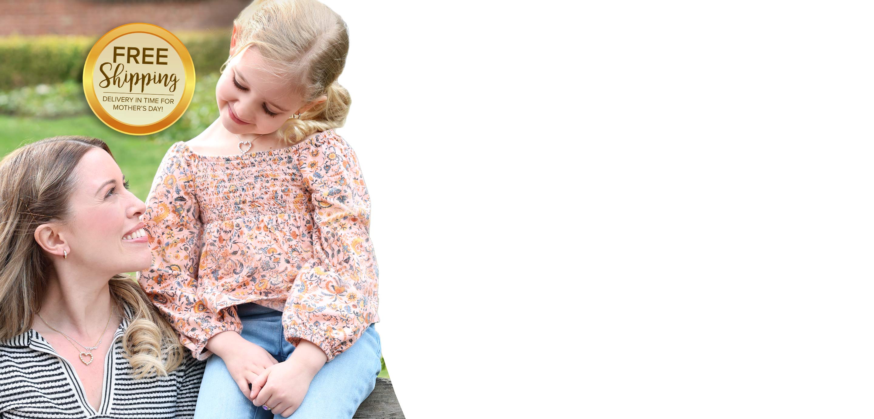 A mother with her daughter sitting together outdoors wearing earrings and necklaces from our Mother's Day Gift Collection 2026.