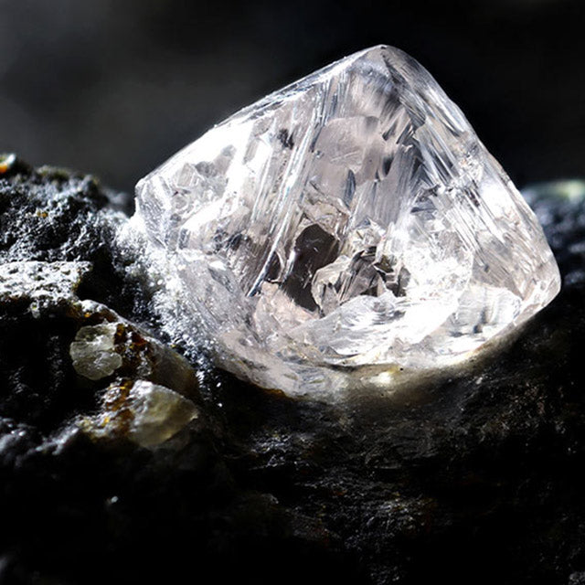 A naturally cut diamond on top of rocks.