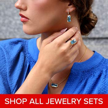 A woman wearing a Blue Topaz jewelry set from Steven Singer Jewelers.