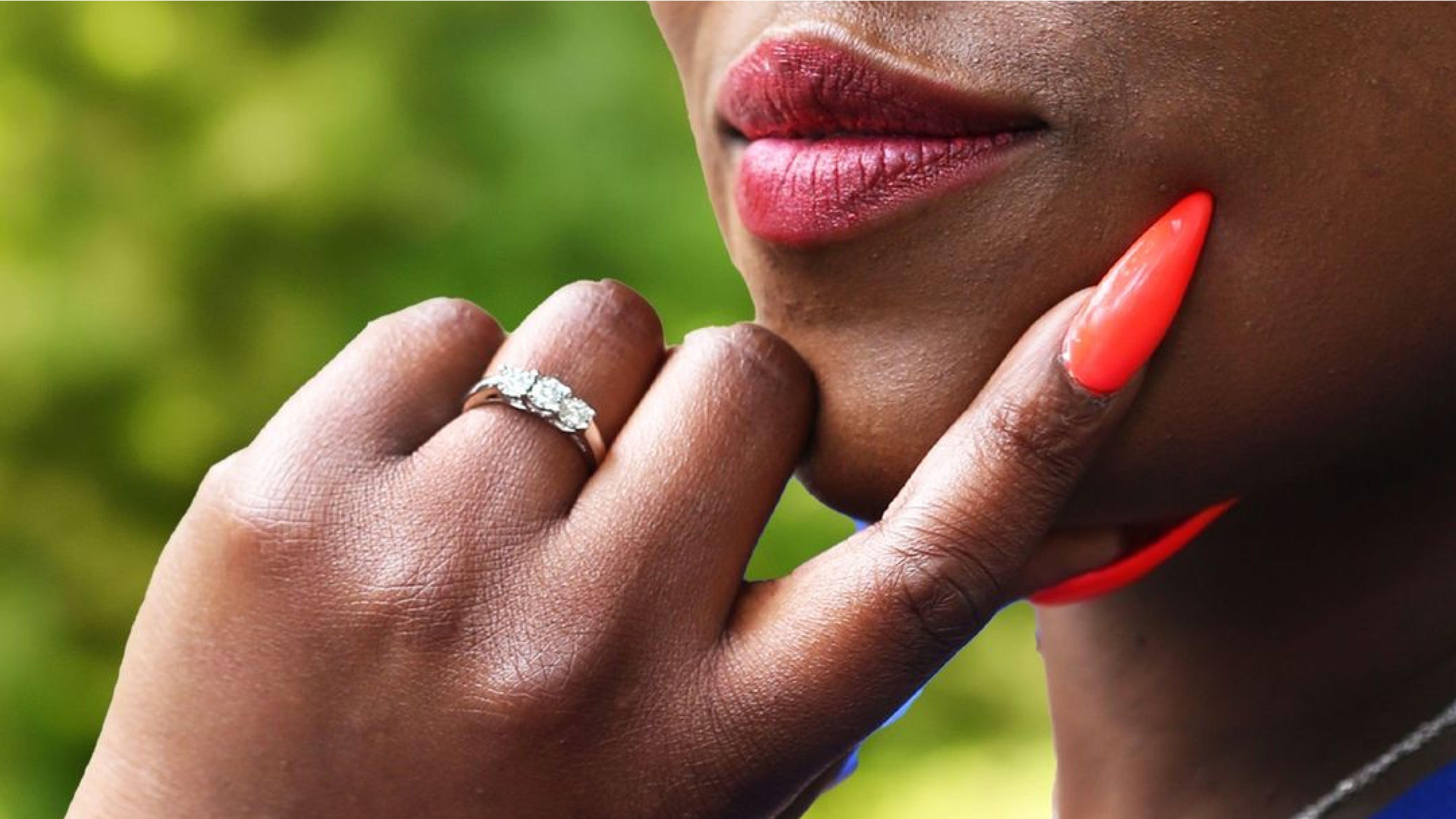 A woman with her hand on her chin showing off one of our diamond fashion rings on her left ring finger.