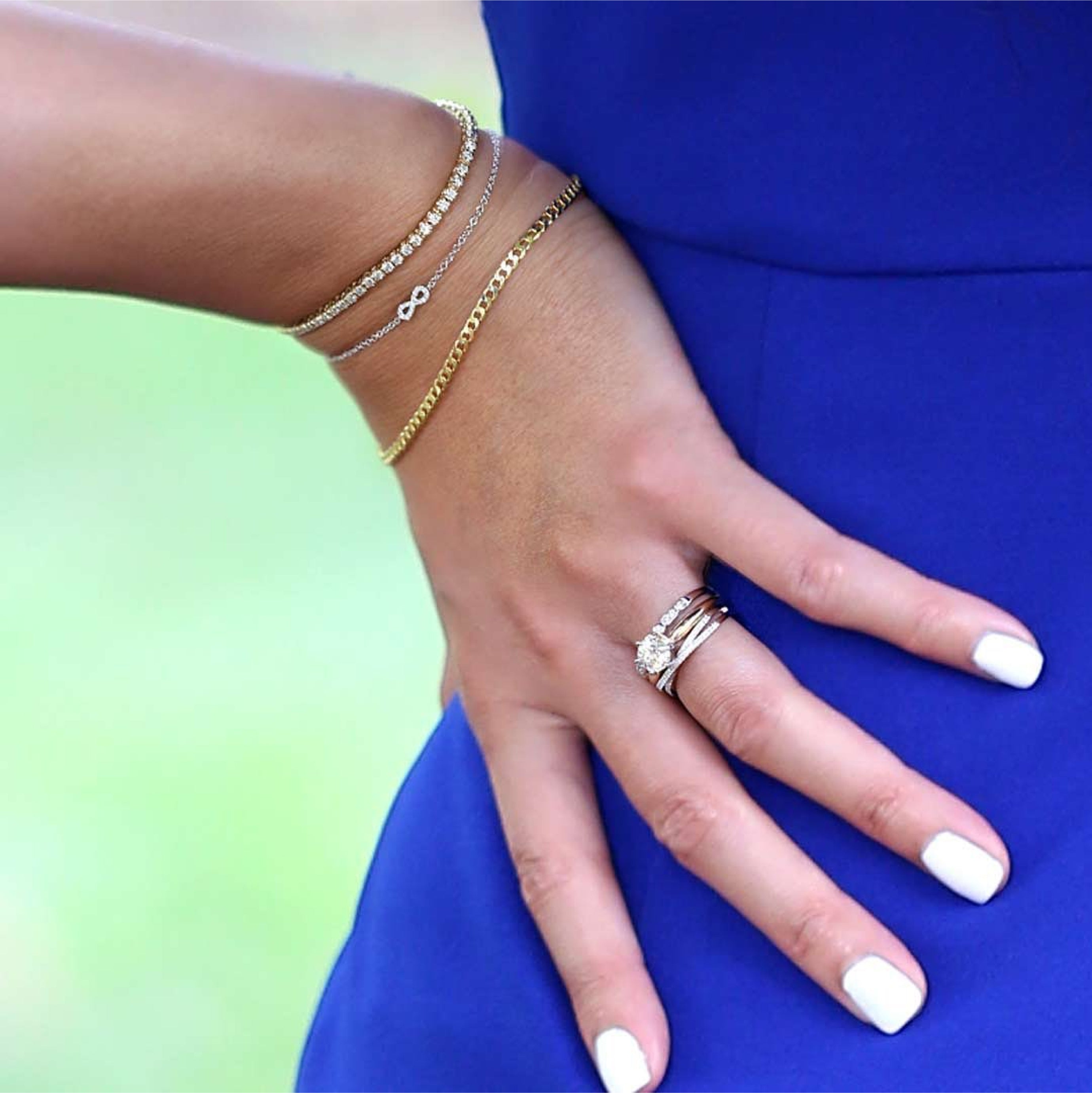 A woman with white nails show how to style our bracelets and stackable rings to give a unique look